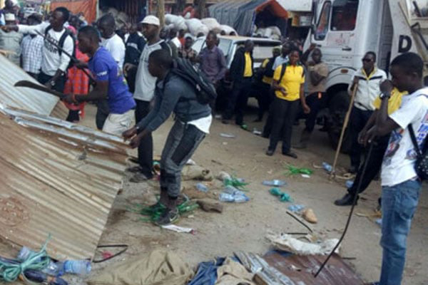 Businessman - Vendors collect remains of their property after Kampala Capital City Authority law enforcement officers demolished illegal structures on city streets in 2018.  